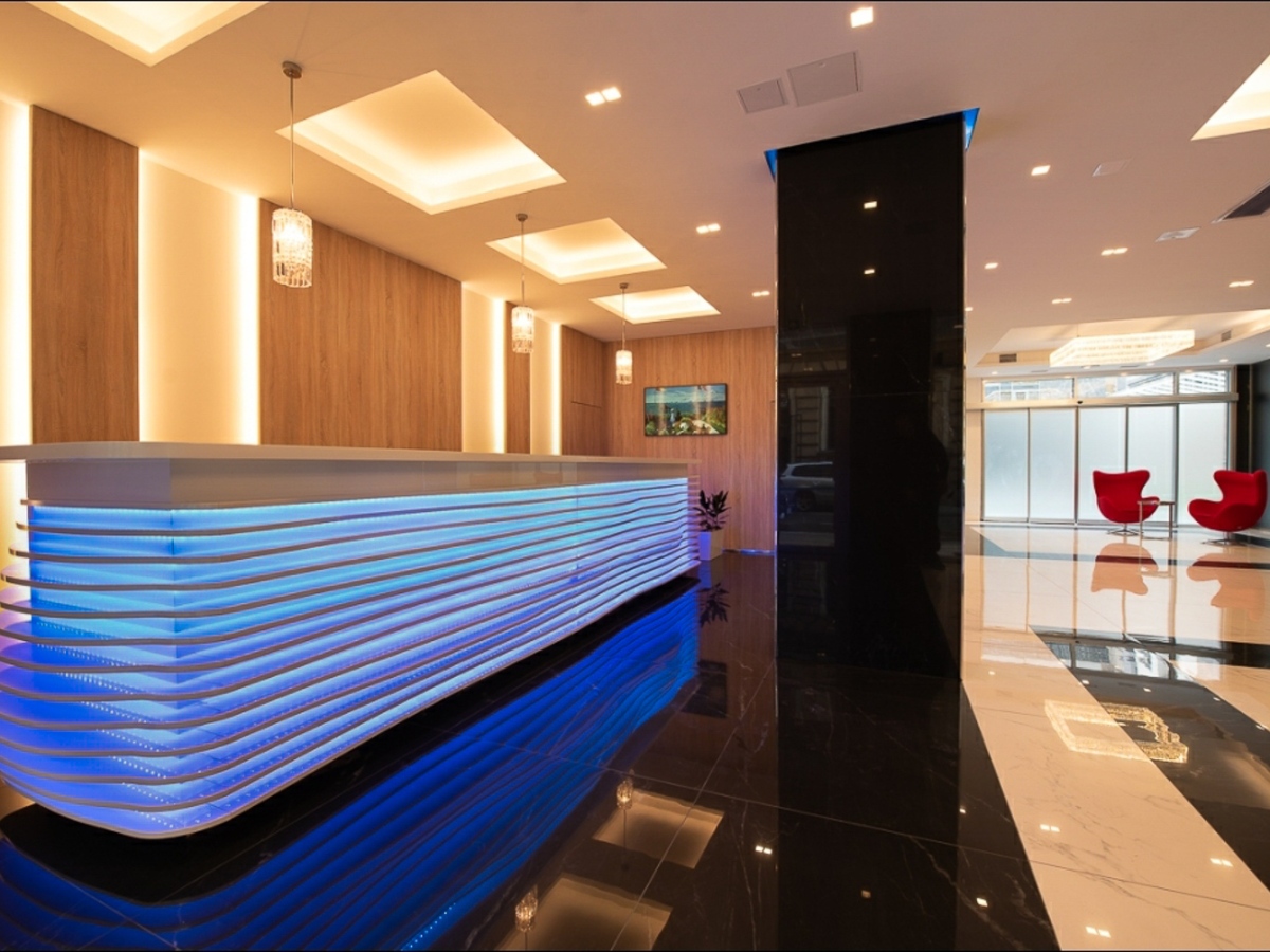 Szállodái recepciós pult, magasfényű fehér MDF lapból, 120 méter színes LED szalaggal
